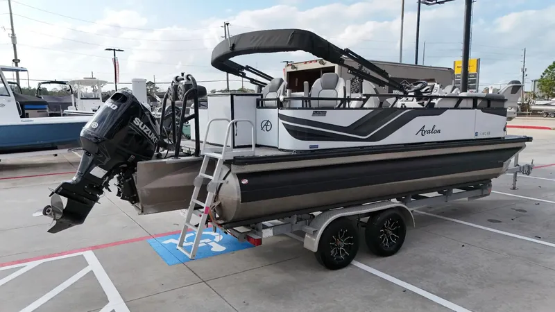 Slide: The Image of 2023 Avalon VEN 2180 FNC pontoon boat on trailer, featuring Suzuki outboard motor. - 3
