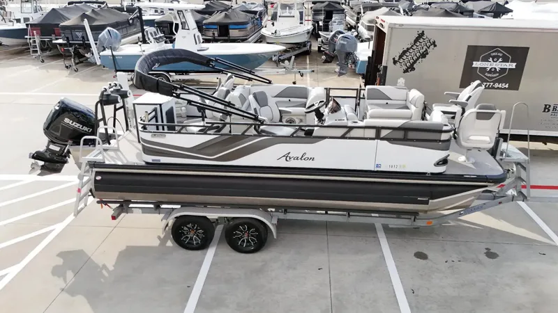 Slide: The Image of 2023 Avalon VEN 2180 FNC pontoon boat on trailer in marina setting. - 6
