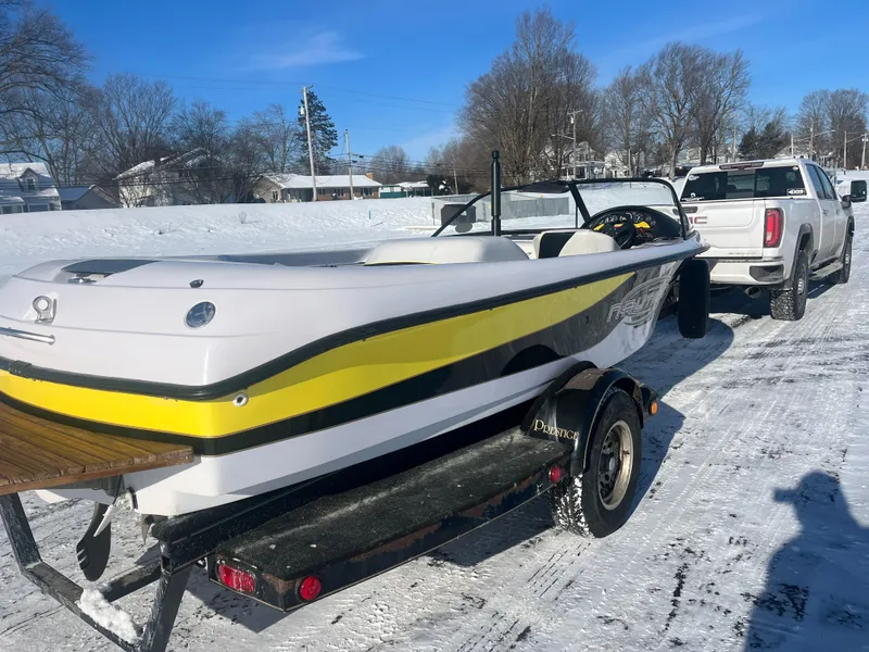 Slide: The Image of 2000 Correct Craft Ski Nautique boat on trailer, snowy background, white and yellow design. - 11