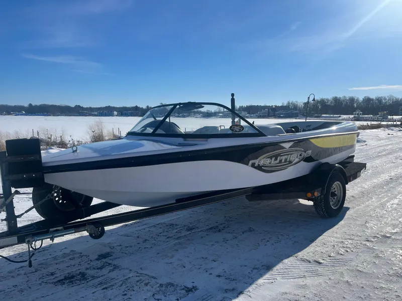 Slide: The Image of 2000 Correct Craft Ski Nautique boat on trailer, parked on snowy ground under clear blue sky. - 7