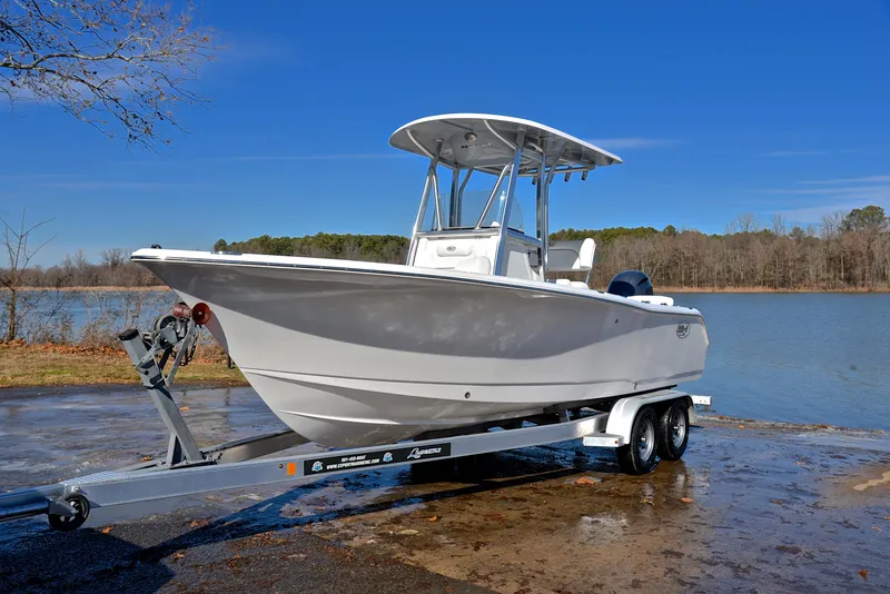 Slide: The Image of 2019 Sea Hunt 225 Ultra boat on trailer by a lake. - 10