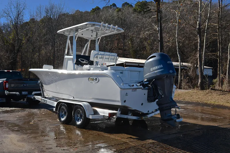 Slide: The Image of 2019 Sea Hunt 225 Ultra boat on trailer with Yamaha engine, parked outdoors. - 12
