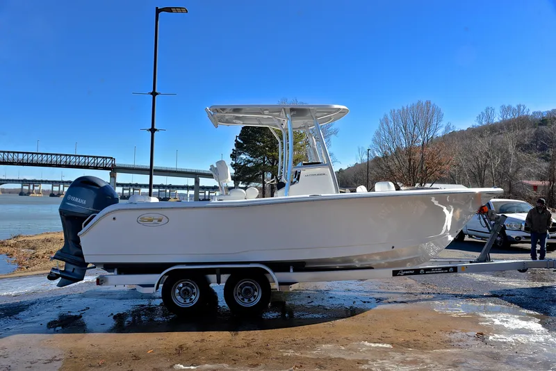 Slide: The Image of 2019 Sea Hunt 225 Ultra boat on trailer by river, clear blue sky. - 15