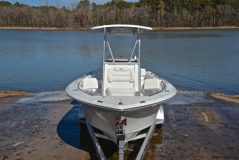 Slide: The Image of 2019 Sea Hunt 225 Ultra boat on a trailer by a lake. - 17