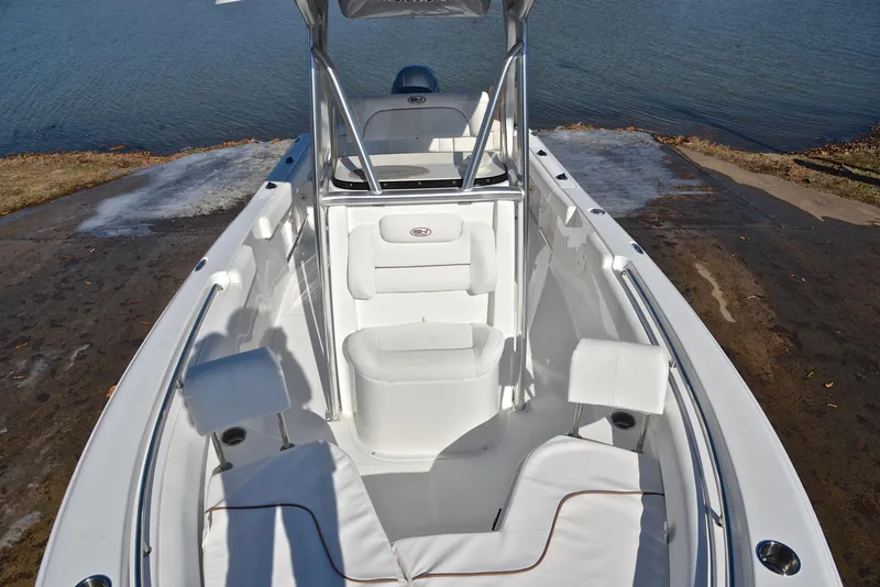 Slide: The Image of 2019 Sea Hunt 225 Ultra boat with white seating, docked by the water. - 21