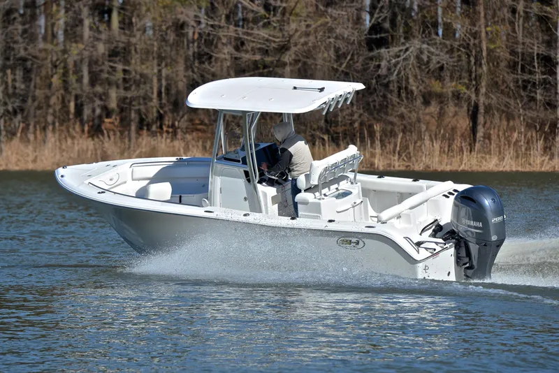 Slide: The Image of 2019 Sea Hunt 225 Ultra boat cruising on a lake with trees in the background. - 6