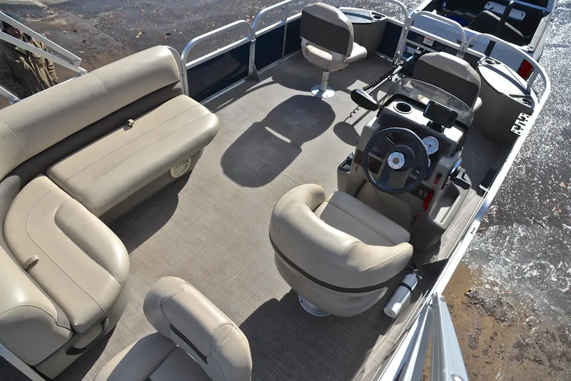 Slide: The Image of 2023 Sun Tracker Bass Buggy 18 DLX pontoon boat interior with beige seating and steering console. - 19