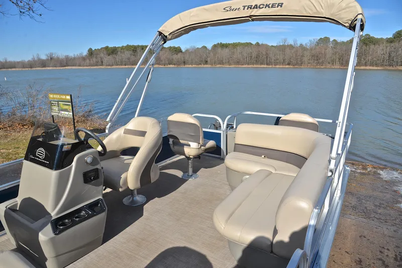 Slide: The Image of 2023 Sun Tracker Bass Buggy 18 DLX pontoon boat on a serene lake. - 22