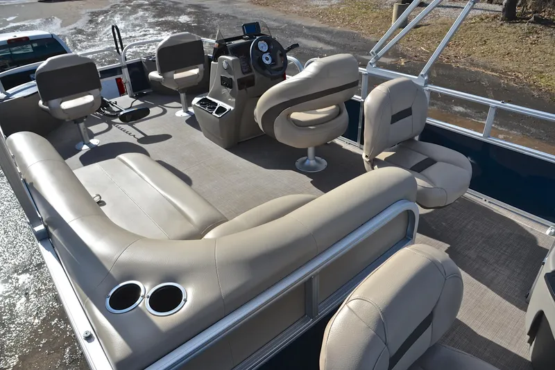 Slide: The Image of 2023 Sun Tracker Bass Buggy 18 DLX interior with beige seating and steering console. - 25