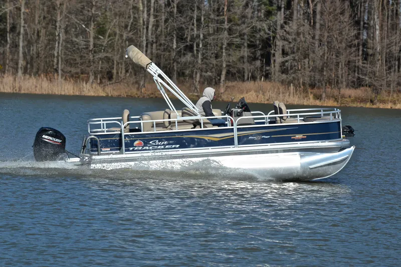 Slide: The Image of 2023 Sun Tracker Bass Buggy 18 DLX pontoon boat cruising on a lake. - 3