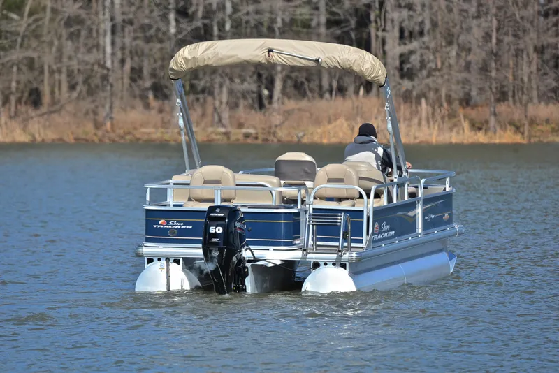 Slide: The Image of 2023 Sun Tracker Bass Buggy 18 DLX pontoon boat on a calm lake. - 7