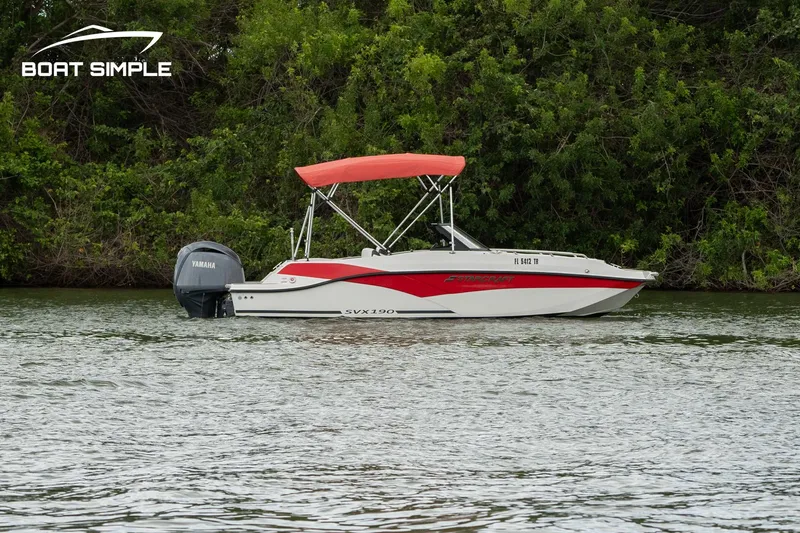 Slide: The Image of 2024 Starcraft SVX 190 OB DC boat with red canopy on a calm lake. - 1