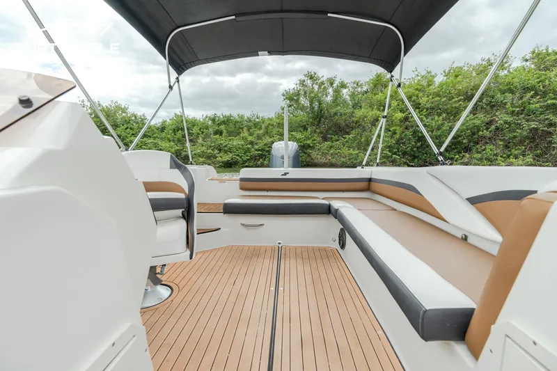 Slide: The Image of 2024 Starcraft SVX 211 OB boat interior with cushioned seating and canopy. - 7