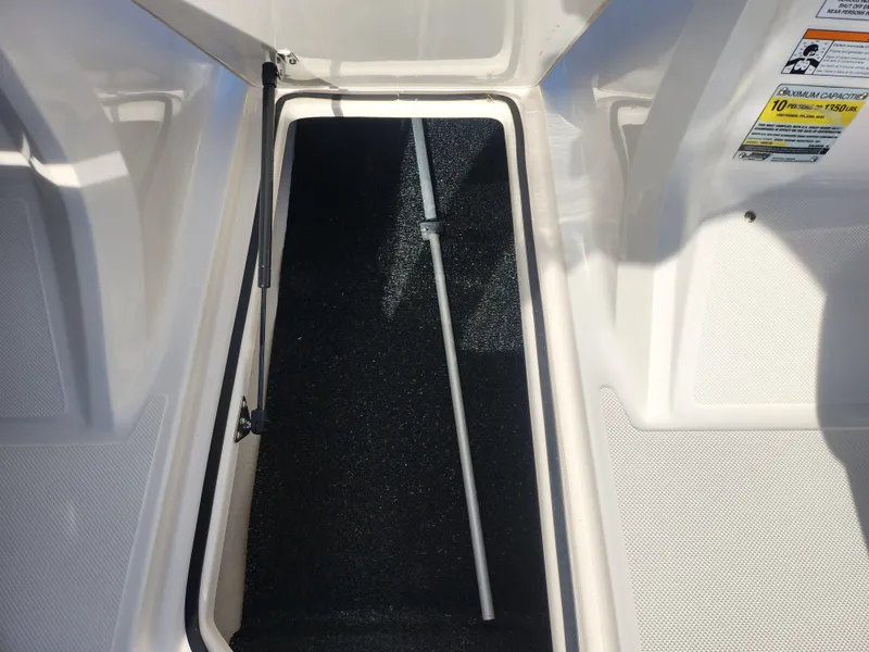Slide: The Image of 2016 Regal 2000 ESX Bowrider storage compartment with open hatch and support rod. - 14
