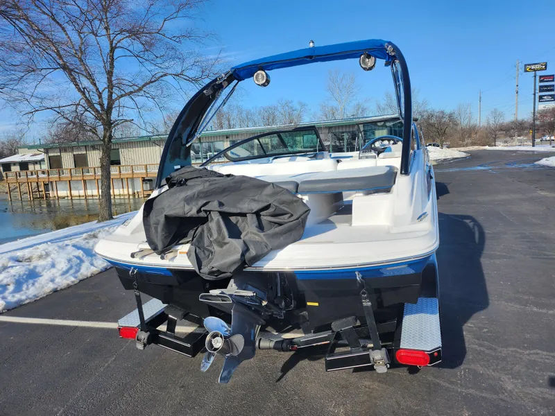 Slide: The Image of 2016 Regal 2000 ESX Bowrider boat on trailer, parked near snowy waterfront. - 2