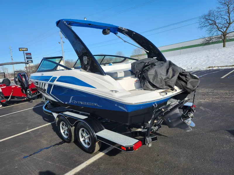 Slide: The Image of 2016 Regal 2000 ESX Bowrider on trailer in parking lot, blue and white design. - 3
