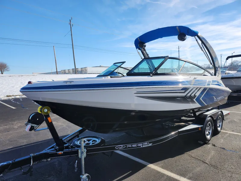 Slide: The Image of 2016 Regal 2000 ESX Bowrider on trailer, sleek design, blue accents, parked outdoors. - 5