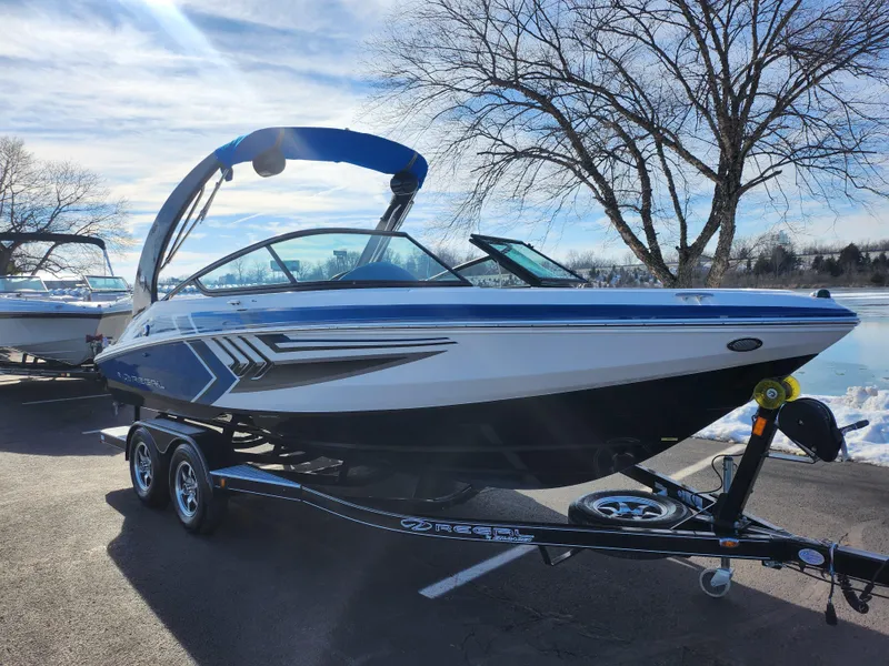 Slide: The Image of 2016 Regal 2000 ESX Bowrider on trailer, parked near a lake with clear skies. - 8