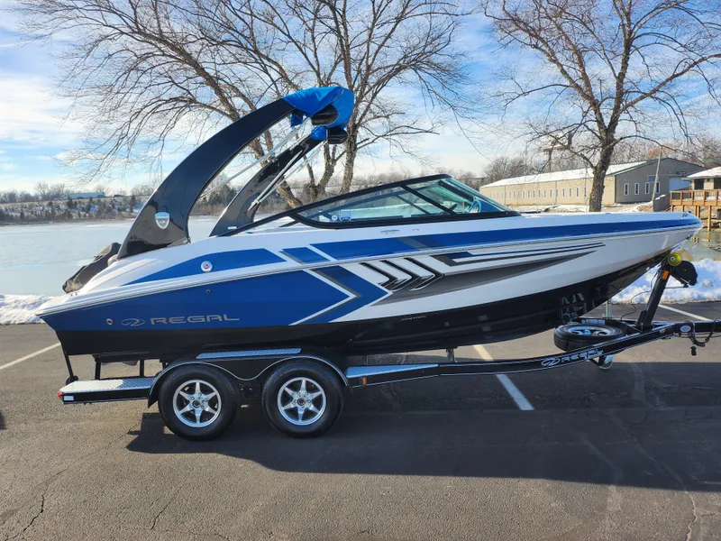 Slide: The Image of 2016 Regal 2000 ESX Bowrider boat on trailer, parked near a lake. - 9