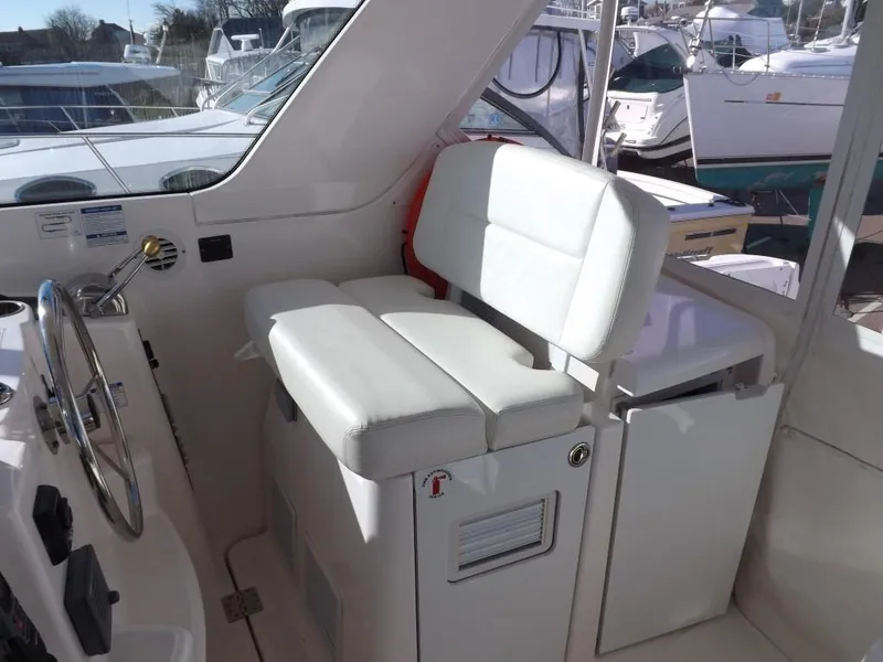 Slide: The Image of 2007 Tiara Yachts 3600 Sovran helm seat with white upholstery and steering wheel. - 12