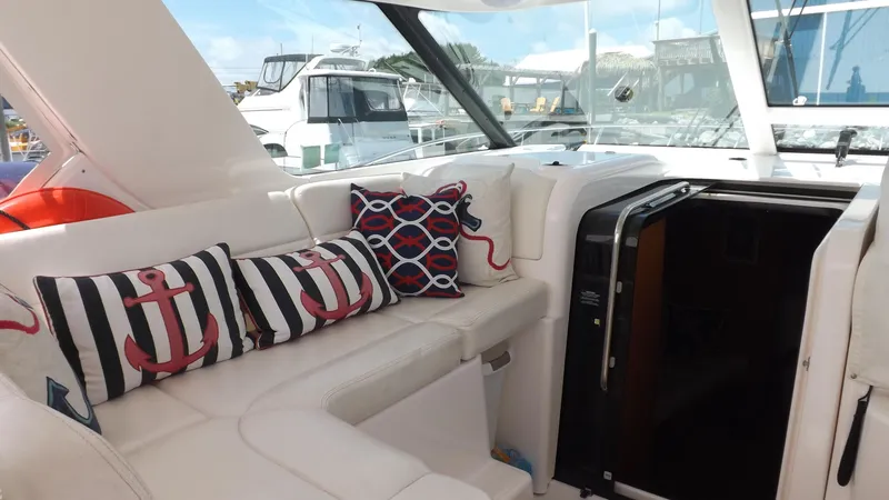 Slide: The Image of 2007 Tiara Yachts 3600 Sovran interior with nautical-themed cushions and sleek white seating. - 14