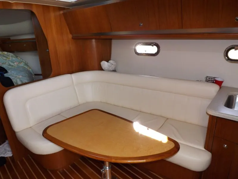 Slide: The Image of 2007 Tiara Yachts 3600 Sovran interior with white seating and wooden table. - 23