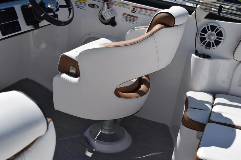 Slide: The Image of 2025 Stingray 211DC boat interior with white and brown seating, steering wheel, and speaker. - 11