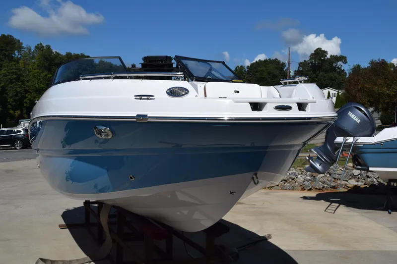Slide: The Image of 2025 Stingray 211DC boat with blue and white hull, displayed outdoors. - 3