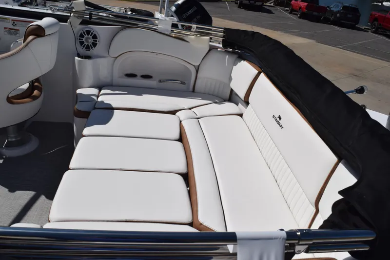 Slide: The Image of 2025 Stingray 211DC boat interior with white cushioned seating and sleek design. - 8