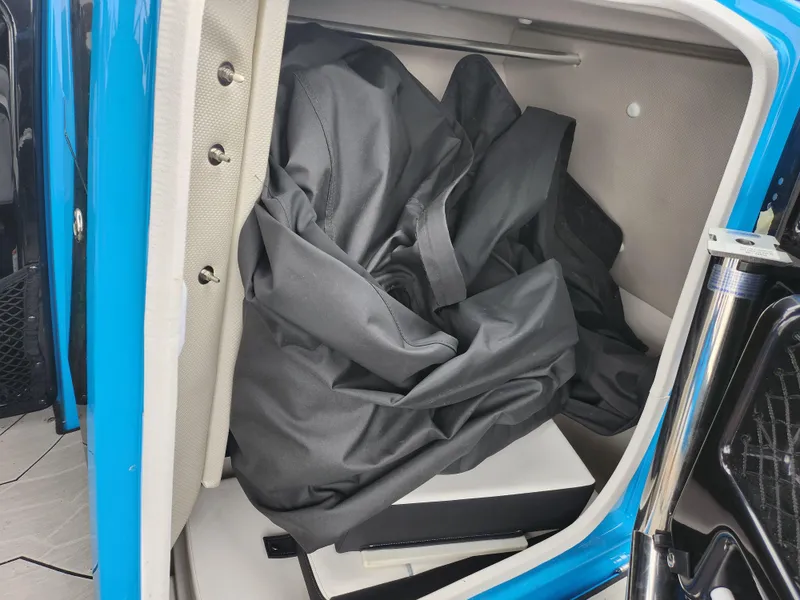 Slide: The Image of Storage compartment of 2022 Yamaha Boats 255XD with black cover inside. - 13
