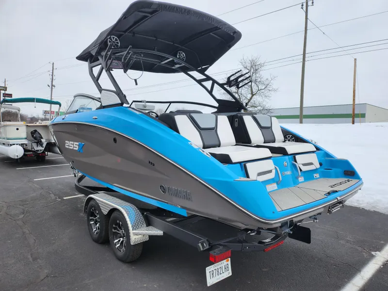 Slide: The Image of 2022 Yamaha Boats 255XD in blue and gray on a trailer, parked on snowy pavement. - 3