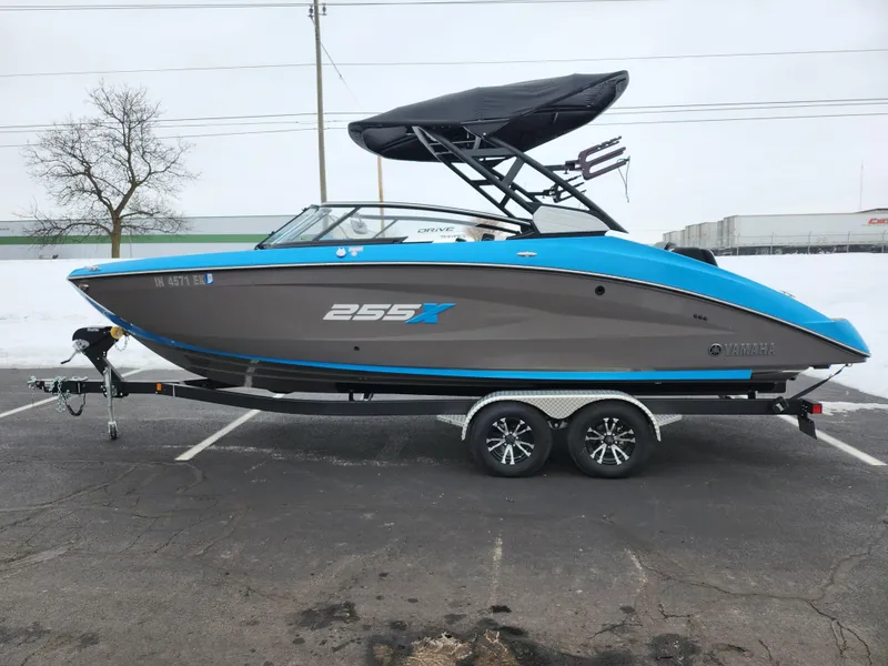 Slide: The Image of 2022 Yamaha Boats 255XD on trailer, blue and gray design, parked outdoors. - 4