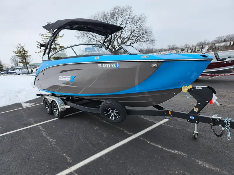 Slide: The Image of 2022 Yamaha Boats 255XD on trailer, blue and gray, parked in snowy lot. - 8