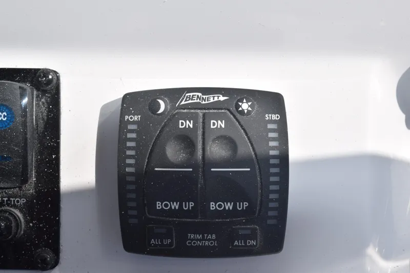 Slide: The Image of Bennett trim tab control panel on 2025 Stingray 216CC boat dashboard. - 14