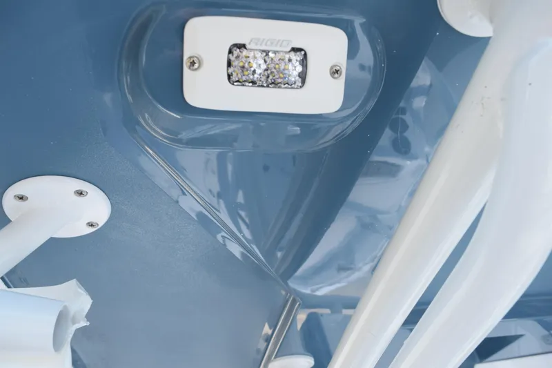 Slide: The Image of Close-up of 2025 Stingray 216CC boat's blue hull with mounted light fixture. - 15