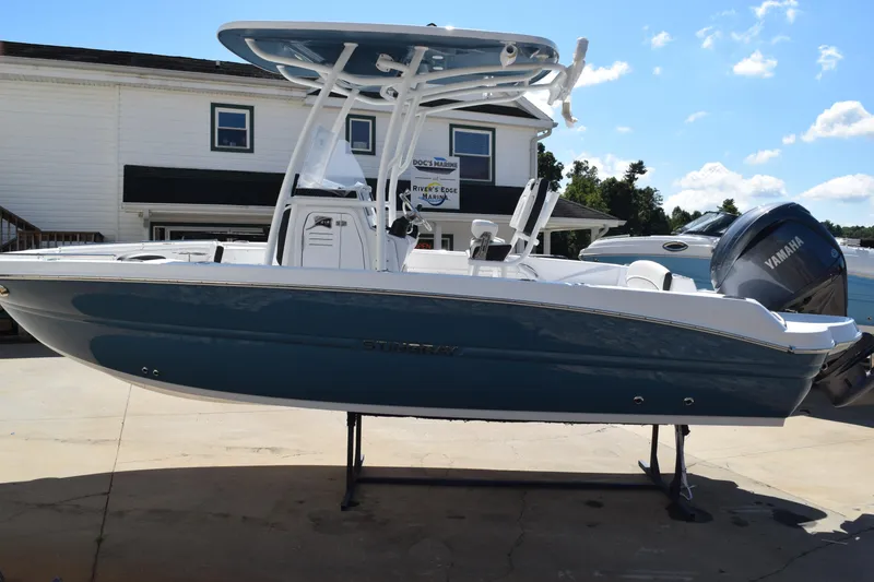Slide: The Image of 2025 Stingray 216CC boat with Yamaha engine, displayed outdoors on a sunny day. - 2