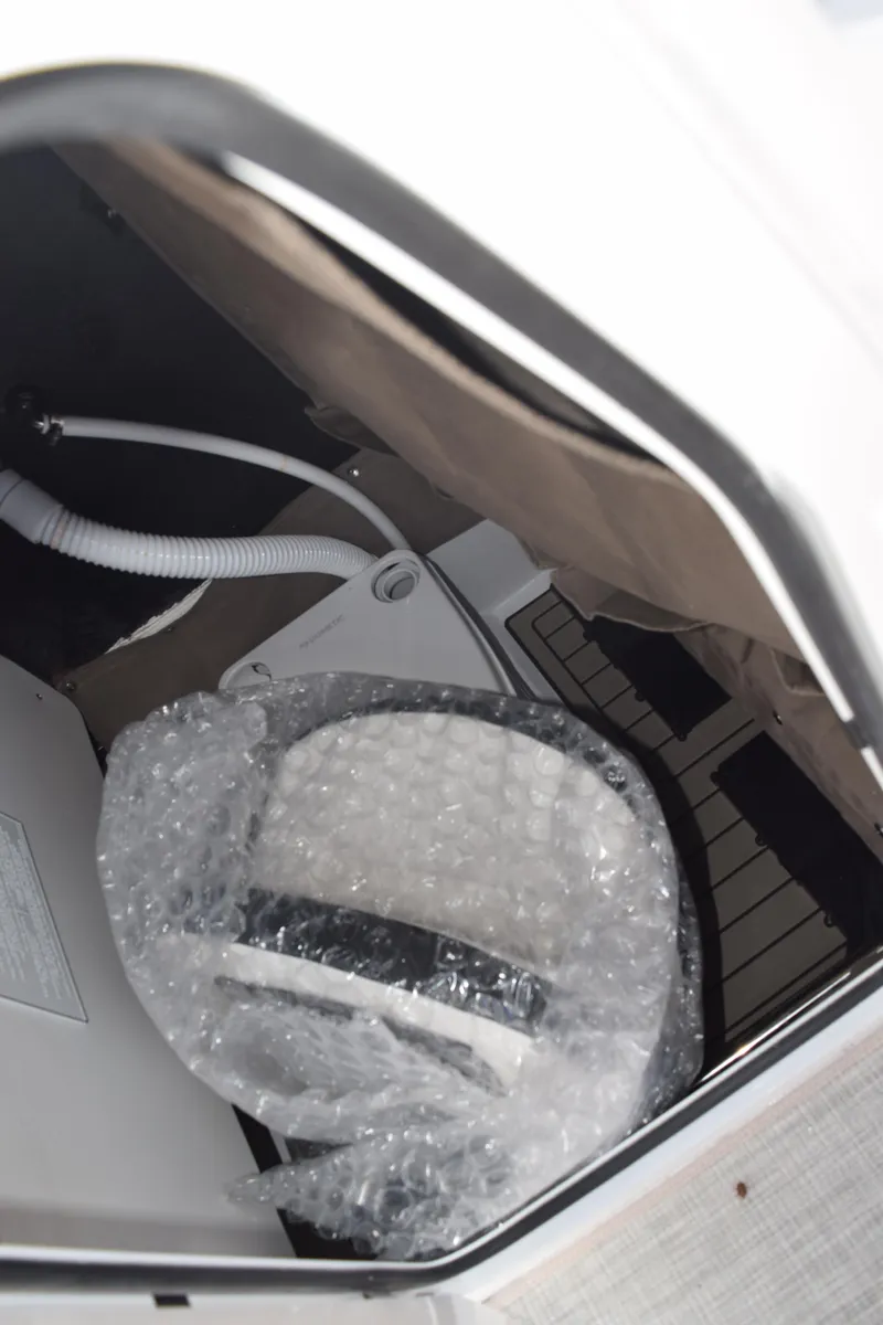 Slide: The Image of 2025 Stingray 216CC boat interior storage with bubble-wrapped equipment. - 21