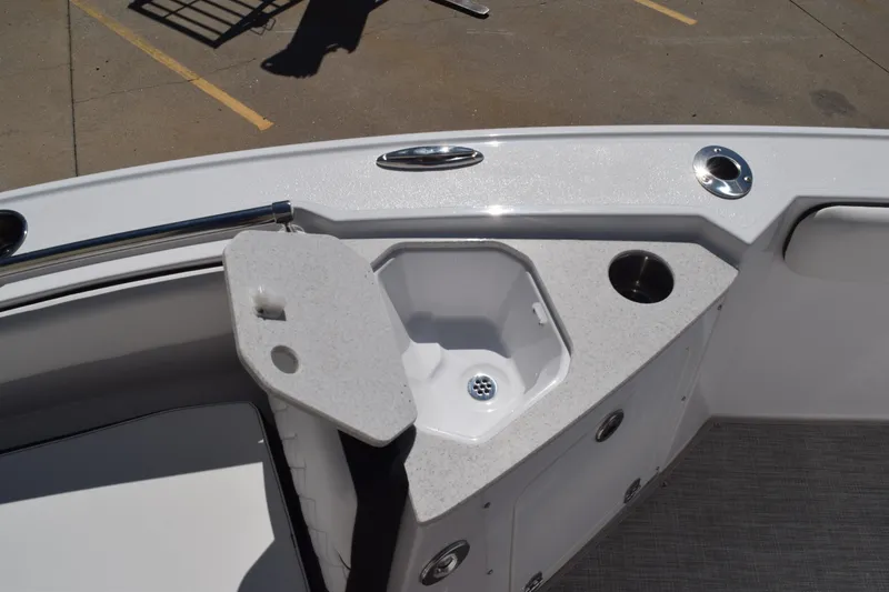 Slide: The Image of 2025 Stingray 216CC boat interior with storage compartment and cup holder. - 25
