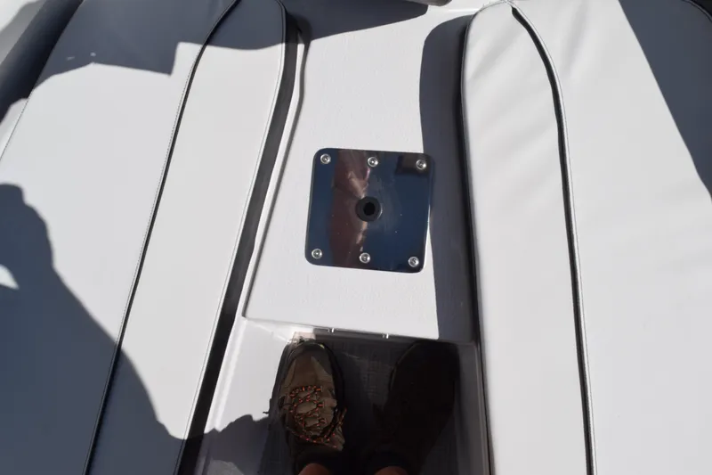 Slide: The Image of 2025 Stingray 216CC boat deck with metal fixture and shadowed foot. - 27