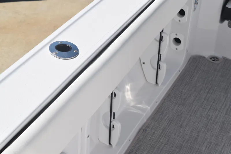 Slide: The Image of 2025 Stingray 216CC boat interior, featuring rod holders and sleek white design. - 29