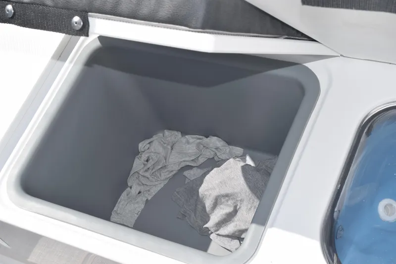 Slide: The Image of Storage compartment in 2025 Stingray 216CC boat, featuring interior space with fabric items. - 39