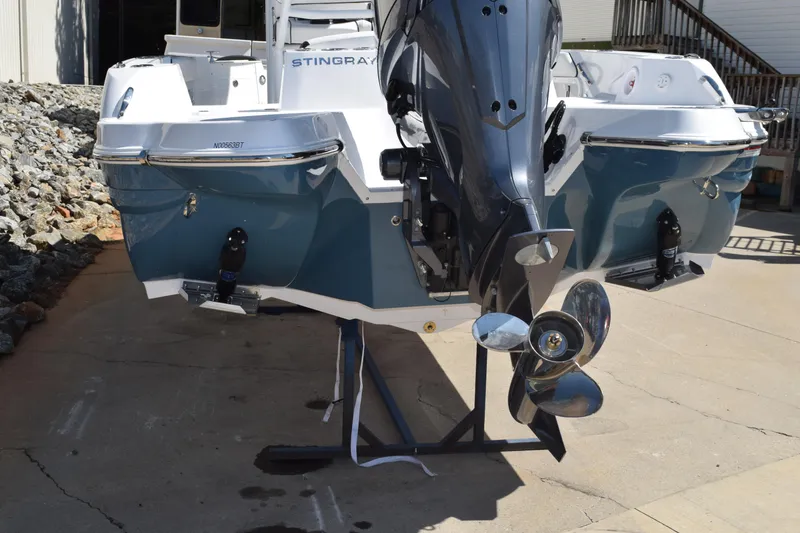 Slide: The Image of 2025 Stingray 216CC boat with outboard motor, displayed on a stand. - 4