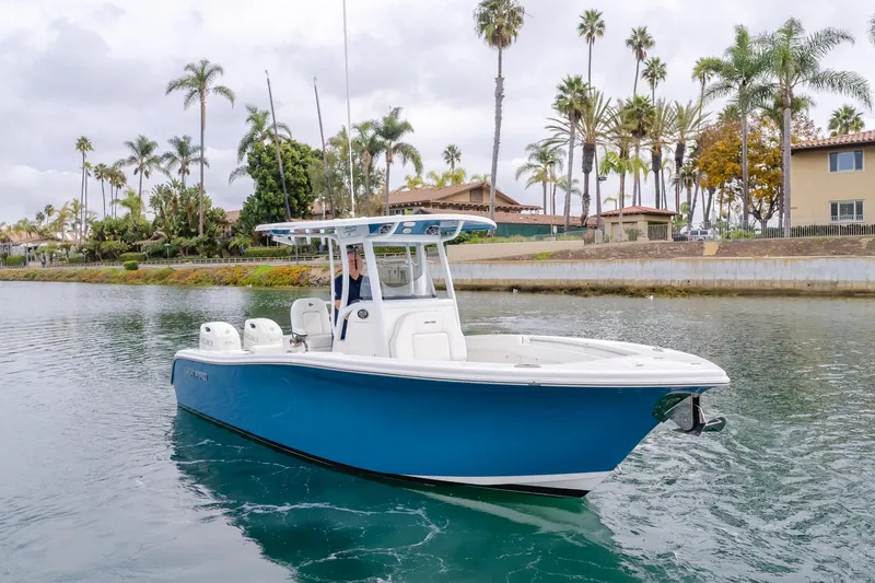 Slide: The Image of 2020 Seapro 25 DLX boat cruising on a scenic waterway with palm trees. - 2