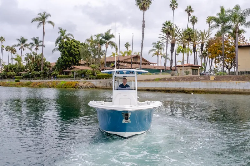 Slide: The Image of 2020 Seapro 25 DLX boat cruising on a scenic waterway with palm trees and buildings. - 4