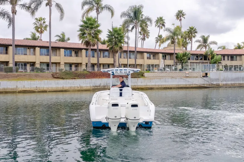 Slide: The Image of 2020 Seapro 25 DLX boat cruising near waterfront buildings and palm trees. - 5