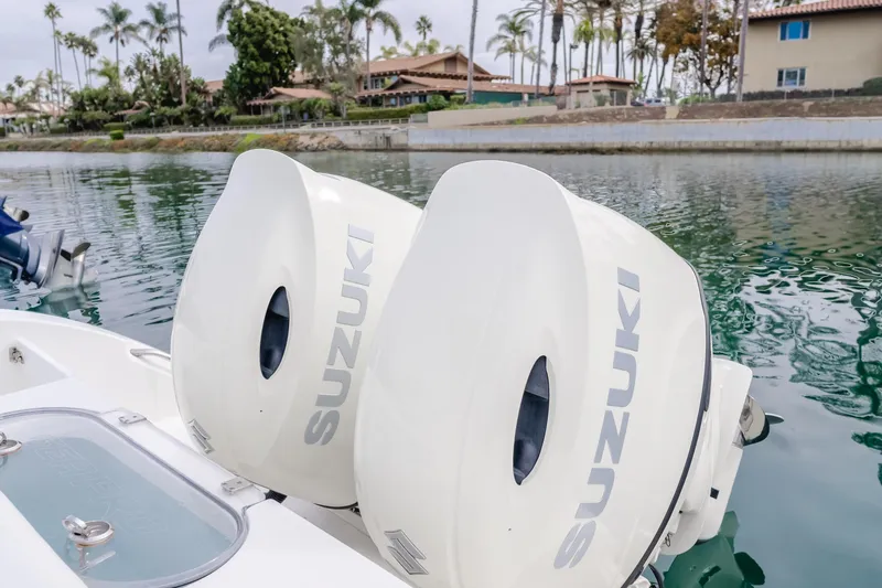 Slide: The Image of 2020 Seapro 25 DLX boat with twin Suzuki outboard motors on a calm waterway. - 7
