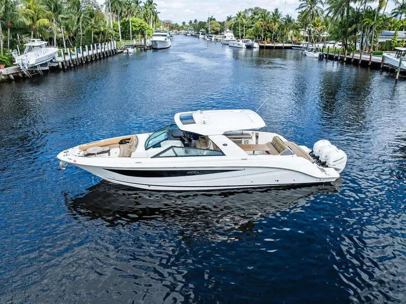 Slide: The Image of 2019 Sea Ray SLX 400 OB cruising on a scenic, tree-lined waterway. - 11