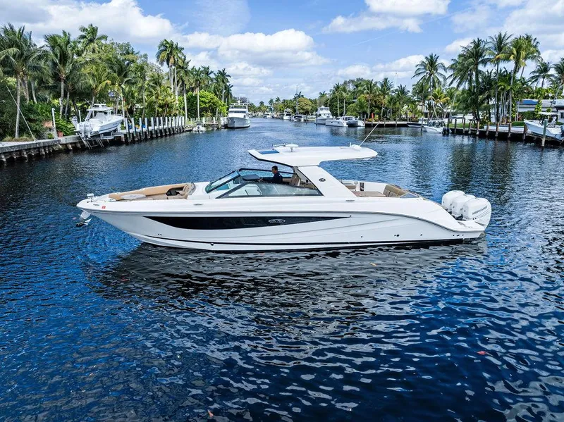 Slide: The Image of 2019 Sea Ray SLX 400 OB cruising on a scenic, palm-lined waterway. - 12