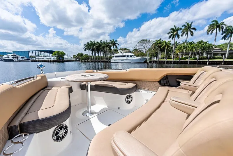 Slide: The Image of 2019 Sea Ray SLX 400 OB luxury boat interior with plush seating and scenic waterfront view. - 17