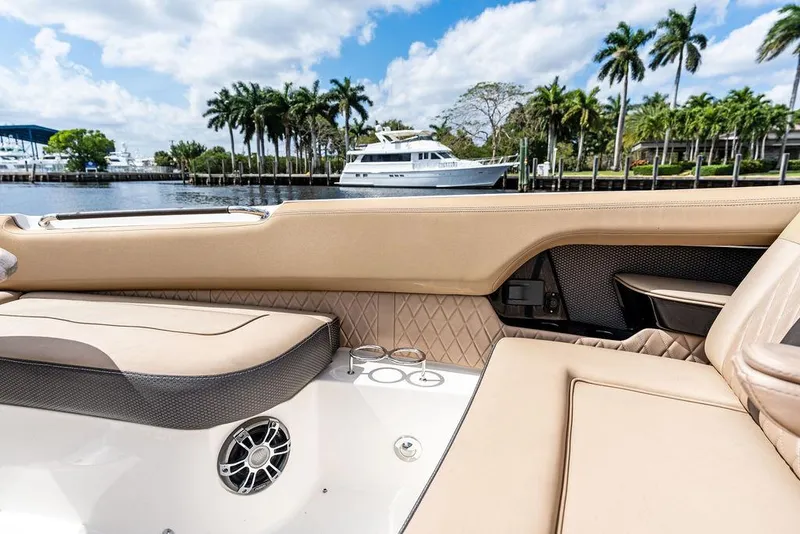 Slide: The Image of 2019 Sea Ray SLX 400 OB interior with luxurious seating, docked near palm trees and yachts. - 20